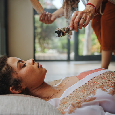 Spiritual, healing and woman with shaman, hands and smudging for cleansing, traditional and inner peace. Holistic, sage and smoke for awakening of person, chakra and ritual to remove negative energy Räucherritual