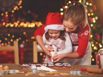Mutter und Tochter backen gemeinsam Weihnachtskekse – gemütlicher Adventmoment in der Küche.
