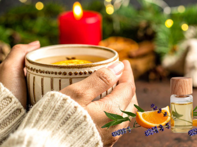 Weihnachtsdeko mit Tannenzweigen, Kerze und ätherischen Ölen – stimmungsvolle Aromaszene für die Adventzeit.